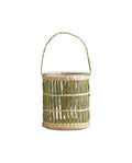 A green glass lantern with paper decoration and a braided handle.