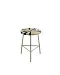 A low MORICE stool with a chrome frame and a striped seat in black and ivory colors.