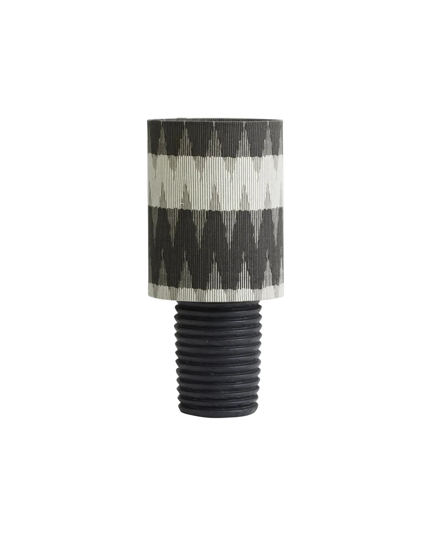 A table lamp with a black aluminum base featuring a grooved finish, and a fabric shade with a rustic pattern. The lamp has an on/off switch and a black fabric cord.