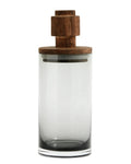 A clear glass storage container with a brown wooden lid, suitable for kitchen or bathroom use, or as a vase or candleholder.